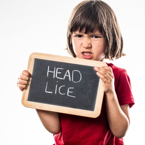 Child holding a sign that says head lice