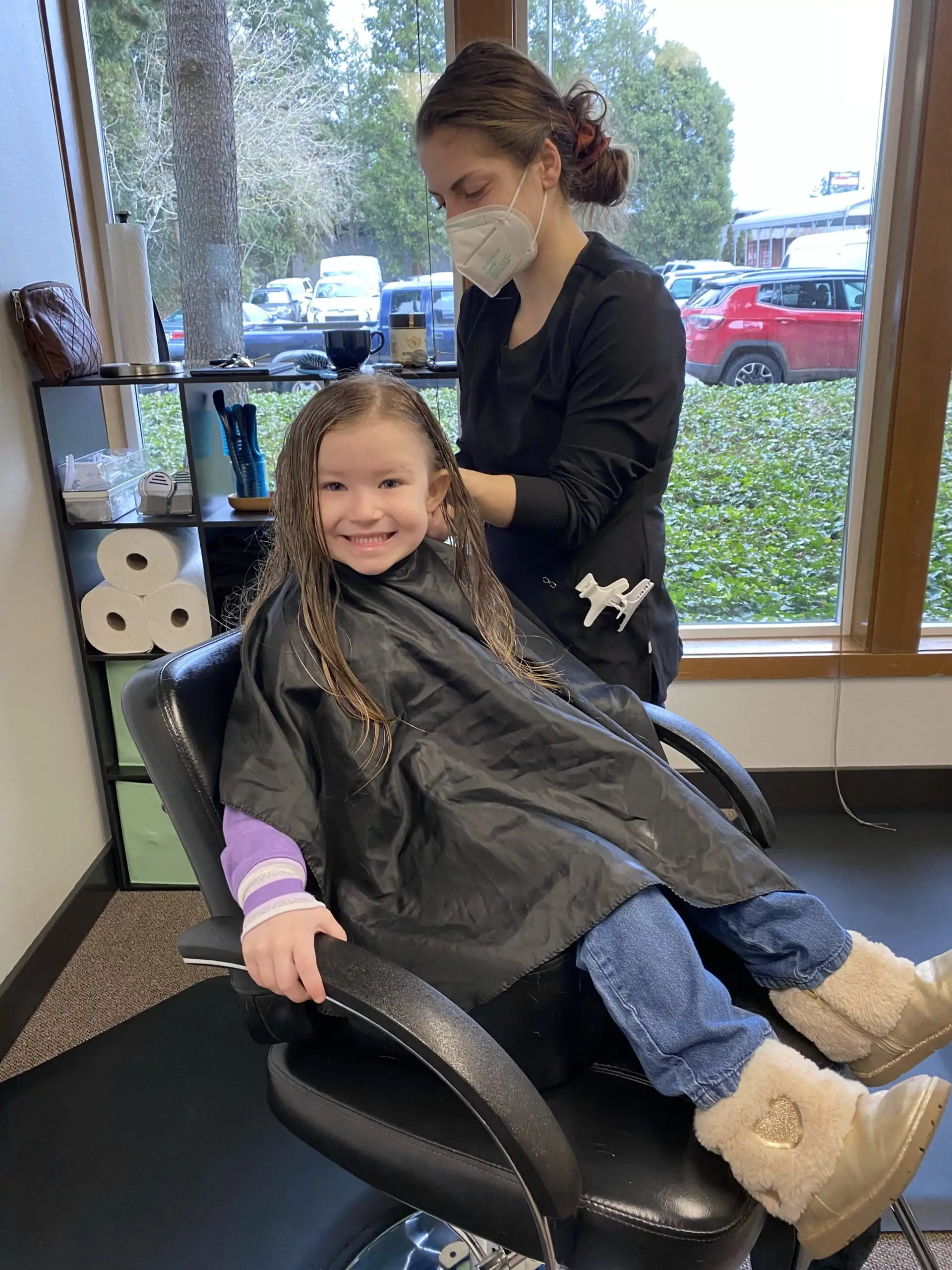 Smiling girl receives head lice treatment on her hair
